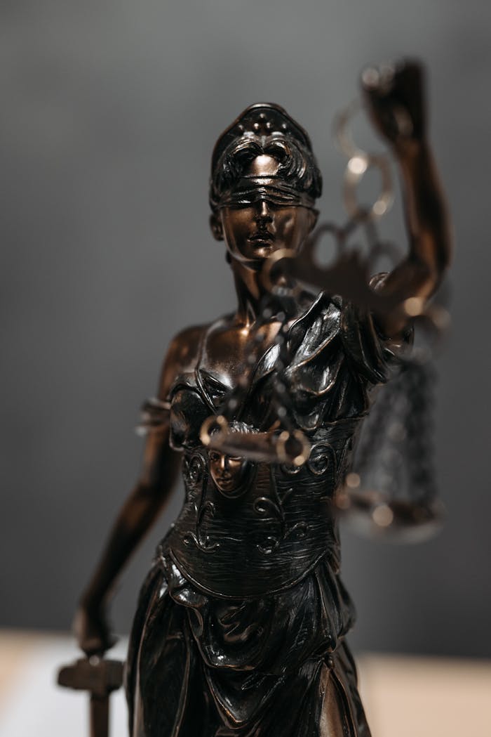 Detailed bronze statue of Lady Justice with scales, symbolizing law and justice.